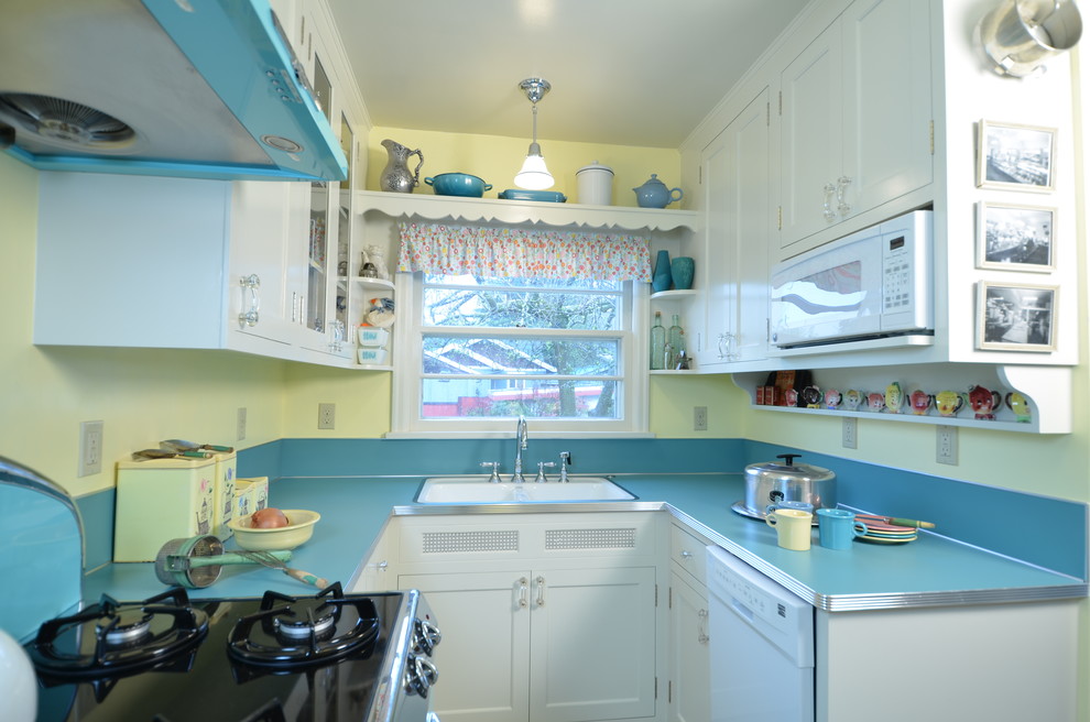 Foto de cocinas en U tradicional pequeño cerrado con fregadero encastrado, armarios estilo shaker, puertas de armario blancas, encimera de laminado, salpicadero azul, electrodomésticos de colores y suelo de linóleo
