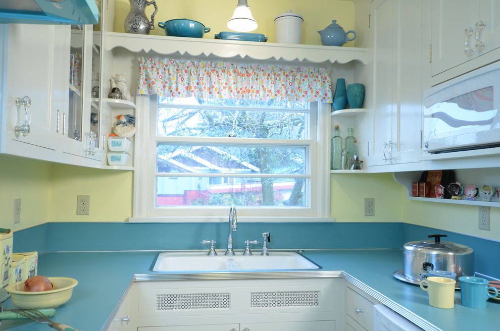 ポートランドにある小さなトラディショナルスタイルのおしゃれなキッチン (ドロップインシンク、シェーカースタイル扉のキャビネット、白いキャビネット、ラミネートカウンター、青いキッチンパネル、カラー調理設備、リノリウムの床) の写真
