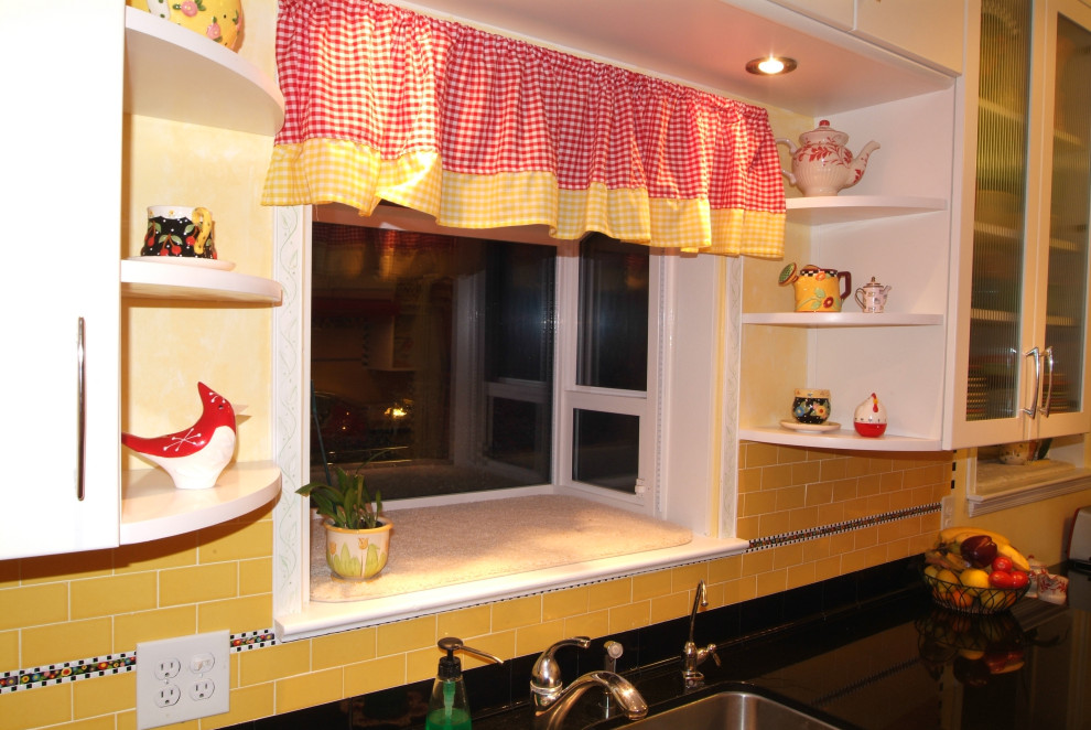 Small eclectic galley enclosed kitchen in San Luis Obispo with a submerged sink, flat-panel cabinets, white cabinets, engineered stone countertops, yellow splashback, metro tiled splashback, coloured appliances, medium hardwood flooring, no island, brown floors and black worktops.