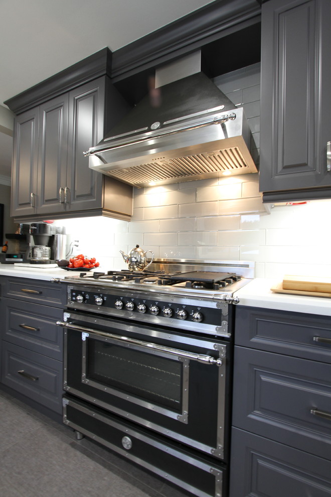 Medium sized contemporary galley kitchen/diner in Toronto with a submerged sink, raised-panel cabinets, grey cabinets, engineered stone countertops, grey splashback, glass sheet splashback, stainless steel appliances, lino flooring and a breakfast bar.