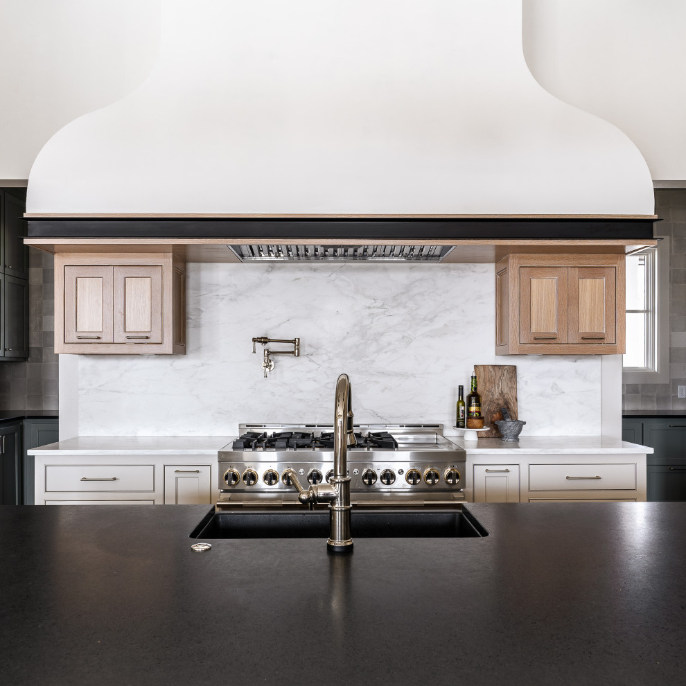 Inspiration for a large traditional u-shaped open plan kitchen in Oklahoma City with a submerged sink, recessed-panel cabinets, light wood cabinets, marble worktops, white splashback, marble splashback, stainless steel appliances, medium hardwood flooring, an island and black worktops.