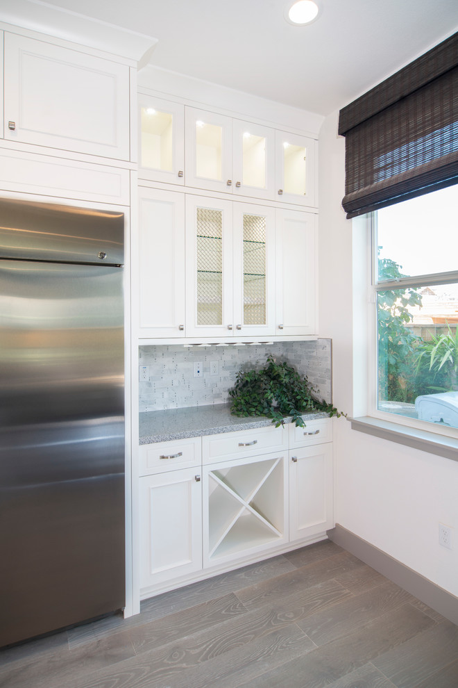 На фото: параллельная кухня в стиле неоклассика (современная классика) с фасадами с утопленной филенкой и белыми фасадами с