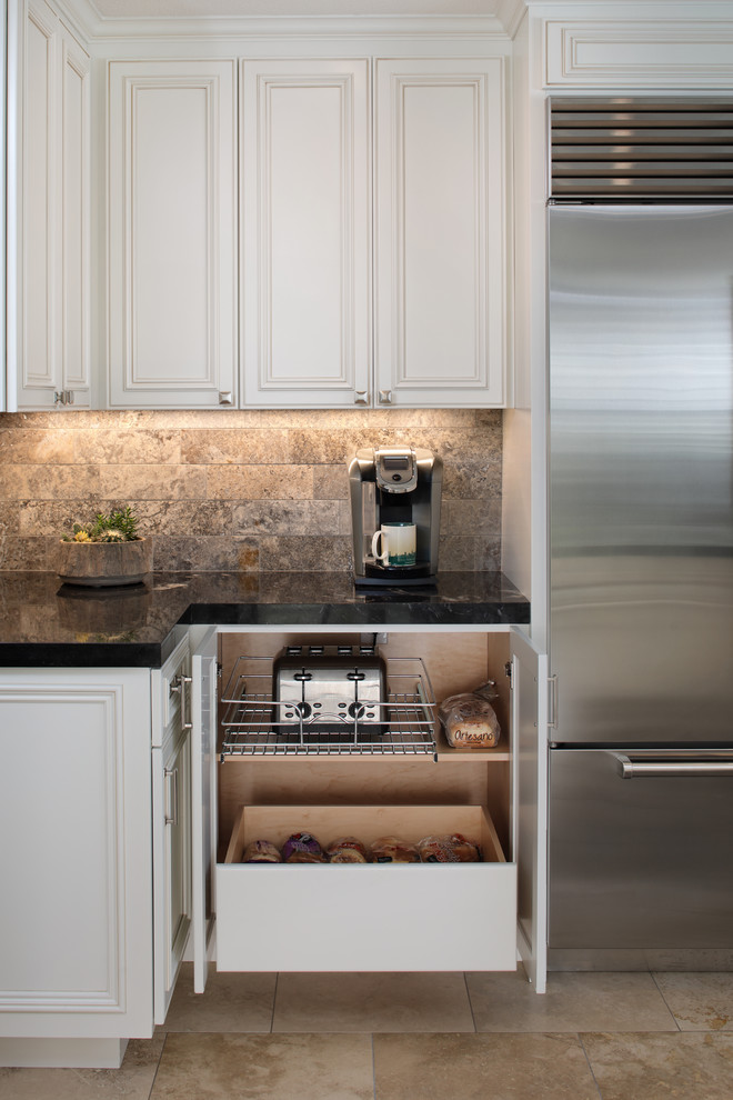 На фото: угловая кухня в классическом стиле с фасадами с утопленной филенкой и белыми фасадами