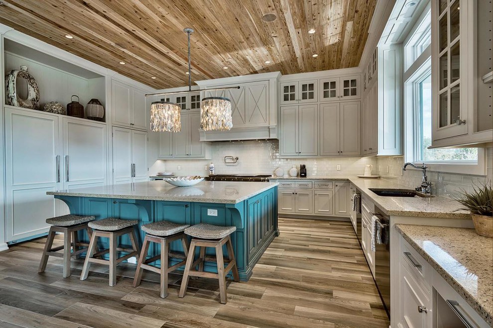 Design ideas for a nautical l-shaped kitchen in Miami with a submerged sink, beaded cabinets, white cabinets, white splashback, stainless steel appliances, light hardwood flooring and an island.