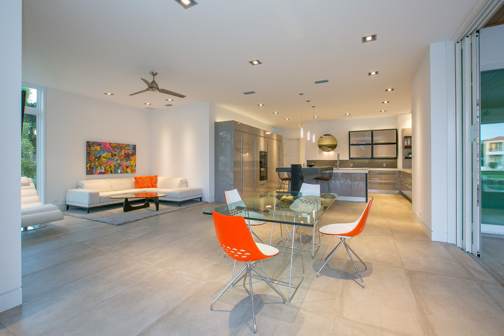 Example of a mid-sized trendy u-shaped concrete floor eat-in kitchen design in Tampa with flat-panel cabinets, gray cabinets, stainless steel appliances and an island