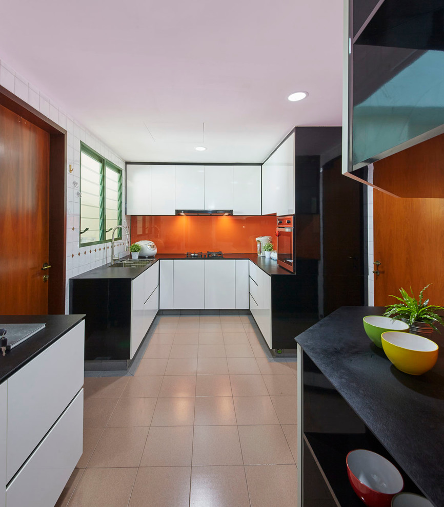 Mittelgroße Moderne Küche in U-Form mit Vorratsschrank, Waschbecken, flächenbündigen Schrankfronten, weißen Schränken, Granit-Arbeitsplatte, Küchenrückwand in Orange, Glasrückwand, Küchengeräten aus Edelstahl und Keramikboden in Singapur