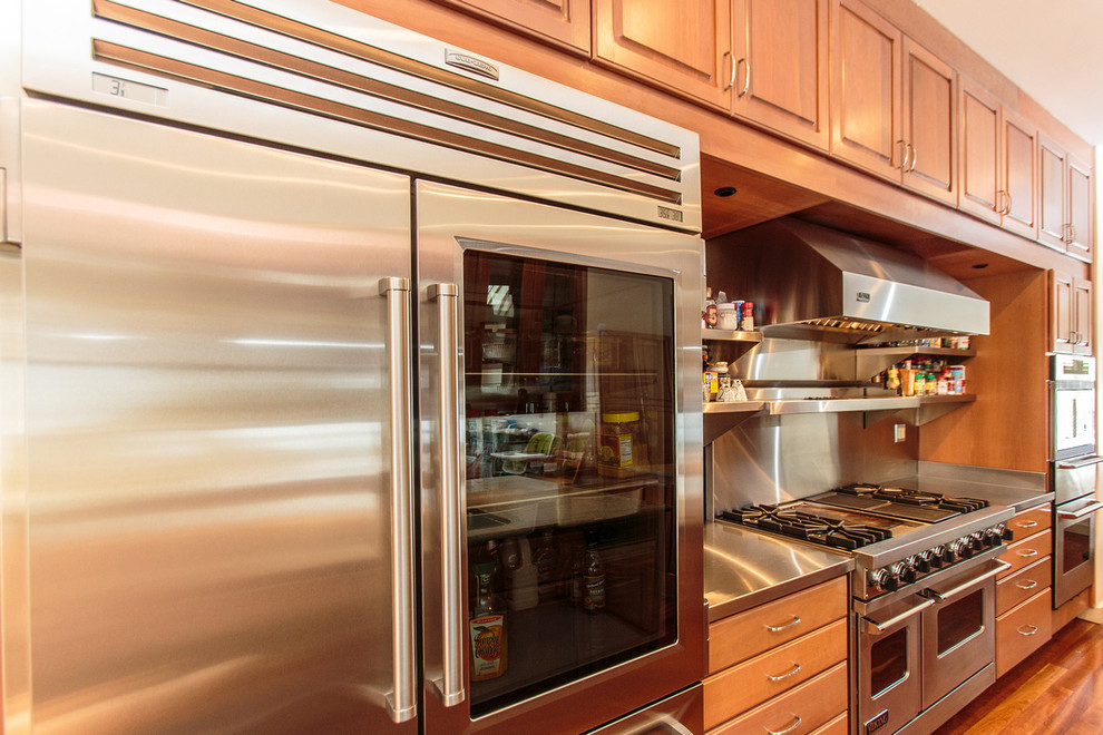 Exempel på ett mycket stort klassiskt u-kök, med en nedsänkt diskho, luckor med infälld panel, skåp i mellenmörkt trä, granitbänkskiva, rostfria vitvaror, mellanmörkt trägolv och flera köksöar