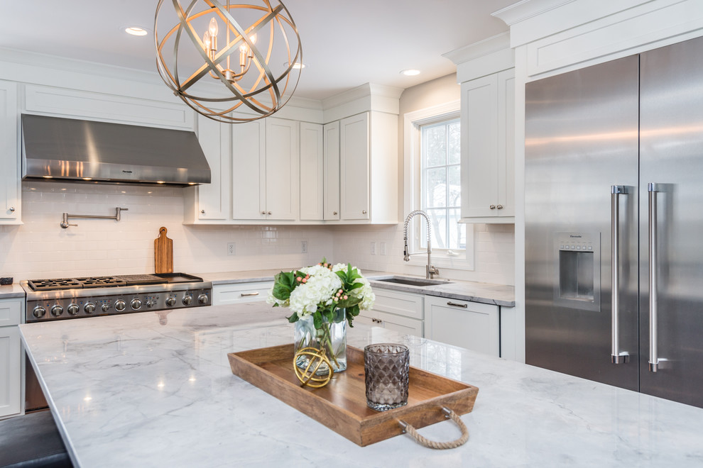 Inspiration for a mid-sized modern u-shaped medium tone wood floor eat-in kitchen remodel in St Louis with an undermount sink, recessed-panel cabinets, white cabinets, granite countertops, white backsplash, subway tile backsplash, stainless steel appliances and an island
