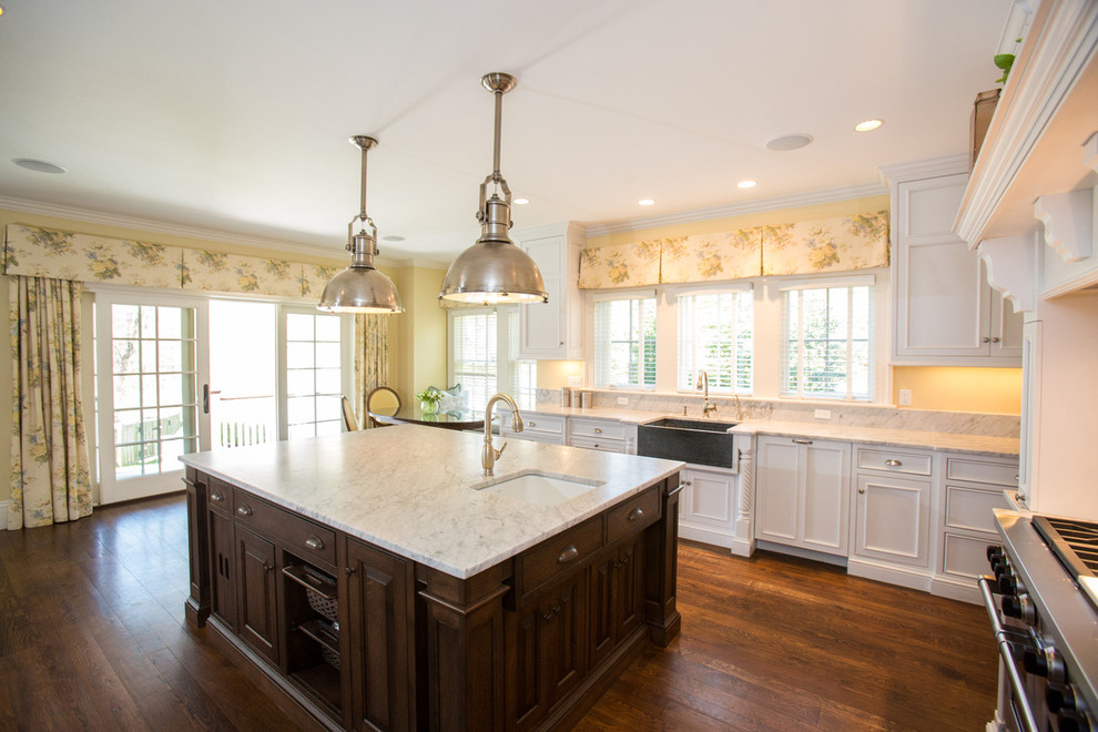Klassische Küche mit profilierten Schrankfronten, weißen Schränken, braunem Holzboden und Kücheninsel in Boston