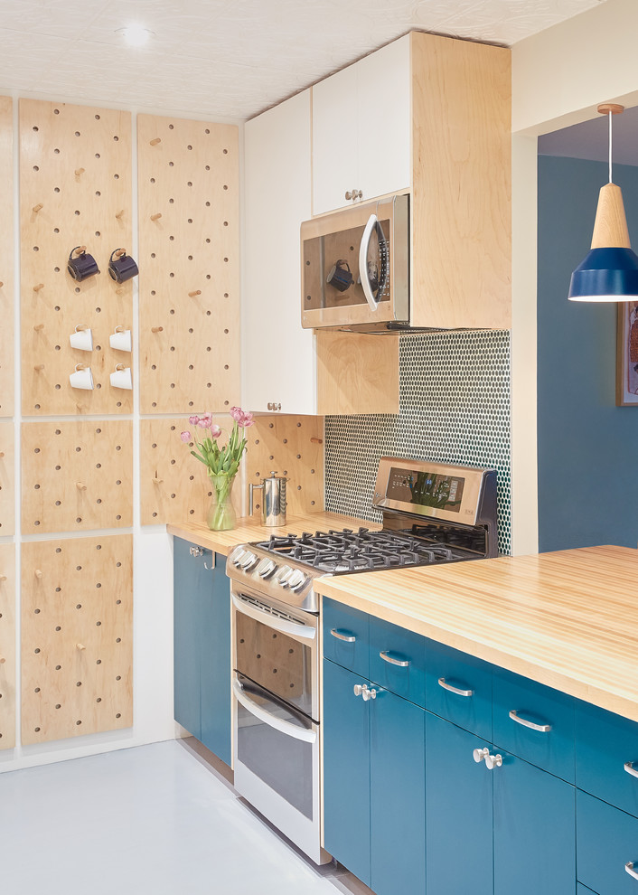 Zweizeilige Moderne Küche ohne Insel mit flächenbündigen Schrankfronten, blauen Schränken, Arbeitsplatte aus Holz, Küchenrückwand in Blau, Rückwand aus Glasfliesen, Küchengeräten aus Edelstahl und grauem Boden in New York