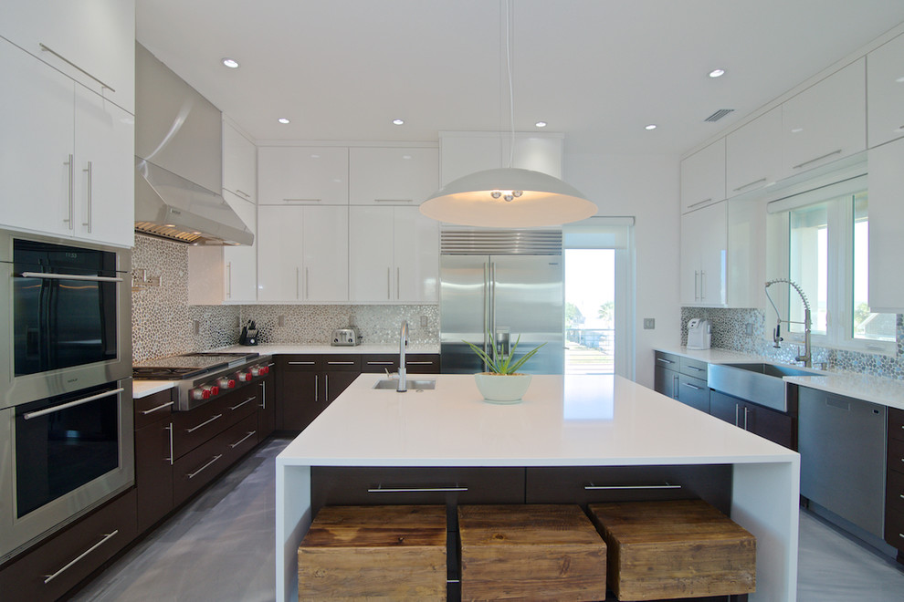 Idéer för att renovera ett mellanstort funkis kök, med en undermonterad diskho, släta luckor, vita skåp, bänkskiva i kvarts, flerfärgad stänkskydd, stänkskydd i mosaik, rostfria vitvaror, betonggolv och en köksö