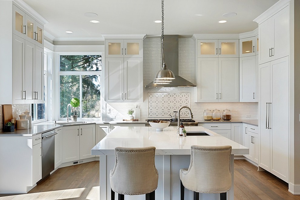 Kitchen - transitional medium tone wood floor kitchen idea in Seattle with shaker cabinets, white cabinets, white backsplash, subway tile backsplash, paneled appliances, an island and gray countertops