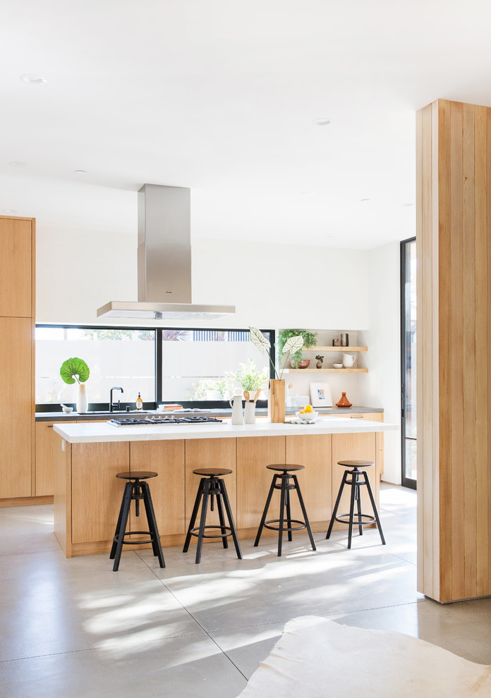 Foto di una cucina contemporanea con ante lisce, ante in legno chiaro, pavimento in cemento, pavimento grigio e top bianco
