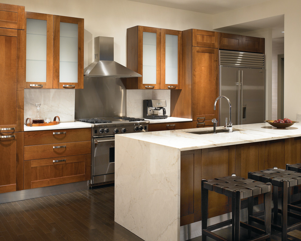 Example of a trendy galley kitchen design in Chicago with stainless steel appliances, an undermount sink, shaker cabinets, medium tone wood cabinets, stone slab backsplash, granite countertops and white backsplash