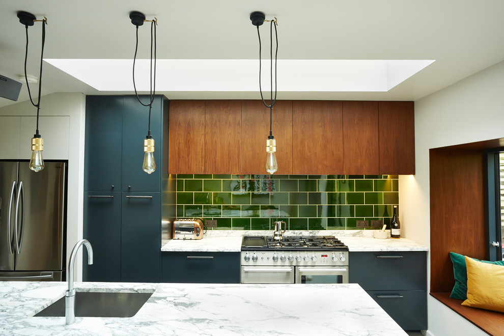 Kitchen - eclectic kitchen idea with an undermount sink, flat-panel cabinets, dark wood cabinets, green backsplash, subway tile backsplash, stainless steel appliances and an island
