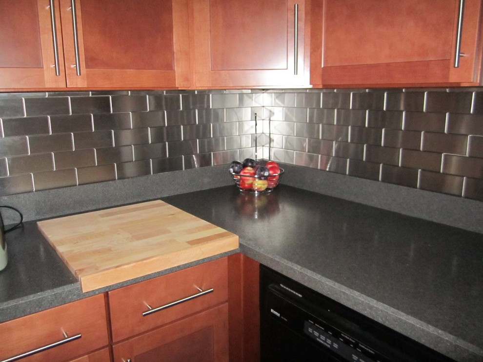 アトランタにあるモダンスタイルのおしゃれなダイニングキッチン (淡色木目調キャビネット、メタリックのキッチンパネル、メタルタイルのキッチンパネル、黒い調理設備) の写真