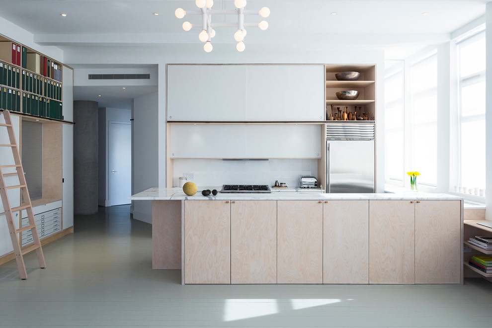 Cette image montre une cuisine design en U et bois clair avec un placard à porte plane, parquet peint, îlot, un sol gris et un plan de travail blanc.