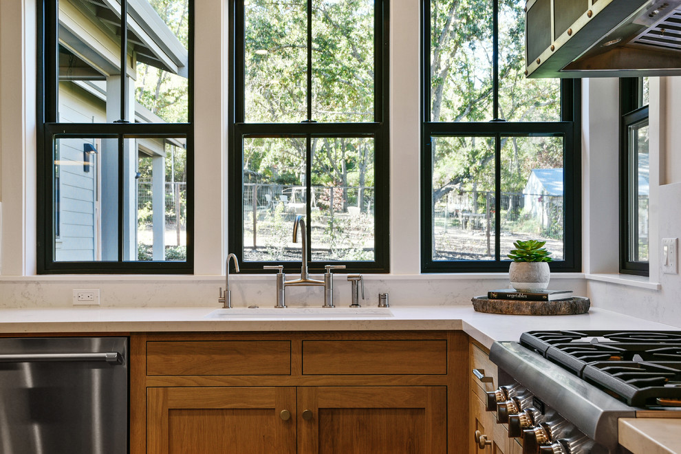 На фото: п-образная кухня в стиле неоклассика (современная классика) с фасадами в стиле шейкер и светлыми деревянными фасадами