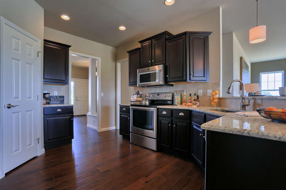 Example of a mid-sized classic u-shaped dark wood floor eat-in kitchen design in Other with an undermount sink, dark wood cabinets, granite countertops, beige backsplash and stainless steel appliances