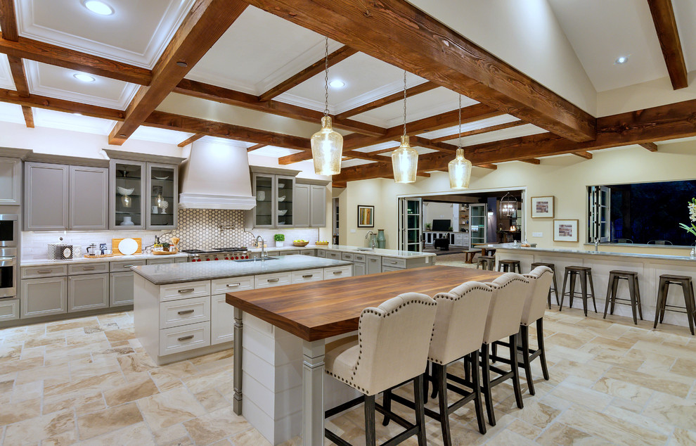 Example of a tuscan beige floor eat-in kitchen design in Phoenix with a single-bowl sink, recessed-panel cabinets, white cabinets, wood countertops, mosaic tile backsplash, stainless steel appliances, two islands and brown countertops