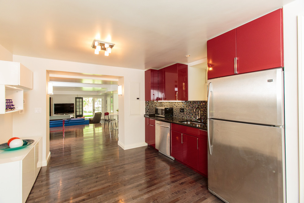 Esempio di una cucina vittoriana di medie dimensioni con ante rosse, elettrodomestici in acciaio inossidabile e pavimento in legno massello medio