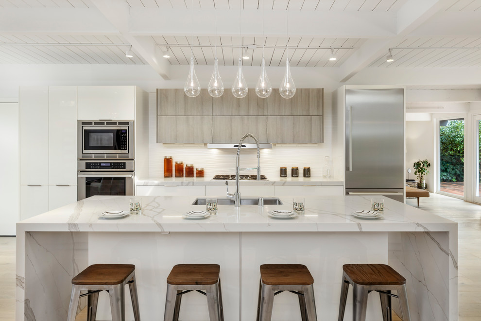 サンフランシスコにあるコンテンポラリースタイルのおしゃれなキッチン (アンダーカウンターシンク、フラットパネル扉のキャビネット、白いキャビネット、白いキッチンパネル、シルバーの調理設備、ベージュの床、白いキッチンカウンター) の写真