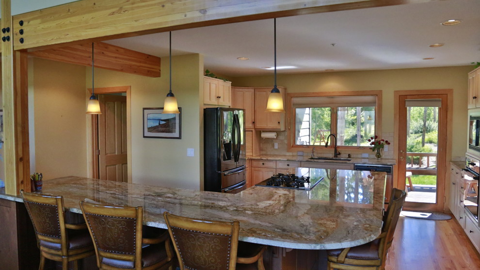 Example of a large trendy l-shaped medium tone wood floor eat-in kitchen design in Denver with an undermount sink, raised-panel cabinets, light wood cabinets, granite countertops, beige backsplash, ceramic backsplash, black appliances and an island