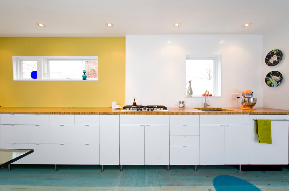 Contemporary single-wall kitchen in DC Metro with flat-panel cabinets, wood worktops, a single-bowl sink, white cabinets, painted wood flooring and turquoise floors.