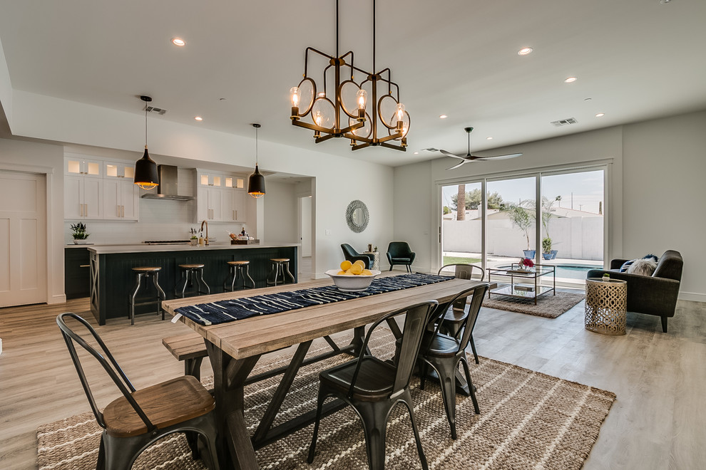Mid-sized farmhouse l-shaped vinyl floor and brown floor eat-in kitchen photo in Phoenix with an undermount sink, recessed-panel cabinets, white cabinets, granite countertops, white backsplash, ceramic backsplash, stainless steel appliances, an island and white countertops