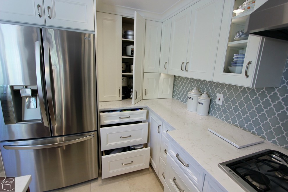 Bild på ett mellanstort funkis kök, med en dubbel diskho, luckor med infälld panel, vita skåp, bänkskiva i kvartsit, grått stänkskydd, stänkskydd i keramik, rostfria vitvaror, klinkergolv i porslin och en köksö