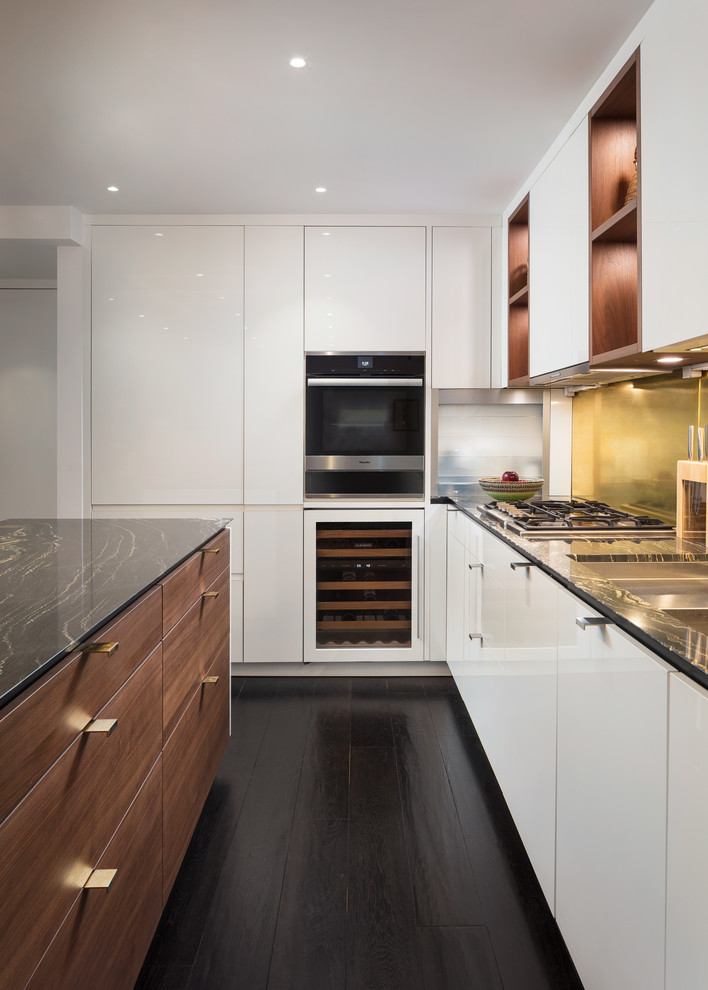 Foto di una cucina minimalista di medie dimensioni con lavello sottopiano, ante lisce, ante bianche, top in marmo, elettrodomestici da incasso, parquet scuro, pavimento nero e top nero