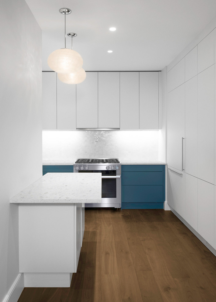 ニューヨークにある高級な広いコンテンポラリースタイルのおしゃれなキッチン (ドロップインシンク、フラットパネル扉のキャビネット、青いキャビネット、大理石カウンター、白いキッチンパネル、モザイクタイルのキッチンパネル、シルバーの調理設備) の写真