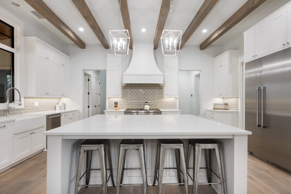 Idéer för att renovera ett stort lantligt vit vitt kök, med en integrerad diskho, luckor med profilerade fronter, vita skåp, marmorbänkskiva, beige stänkskydd, stänkskydd i keramik, rostfria vitvaror, ljust trägolv, en köksö och beiget golv