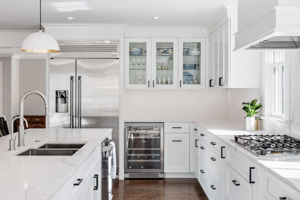 Kitchen - transitional l-shaped dark wood floor and brown floor kitchen idea in Denver with an undermount sink, shaker cabinets, white cabinets, white backsplash, stainless steel appliances, an island and white countertops