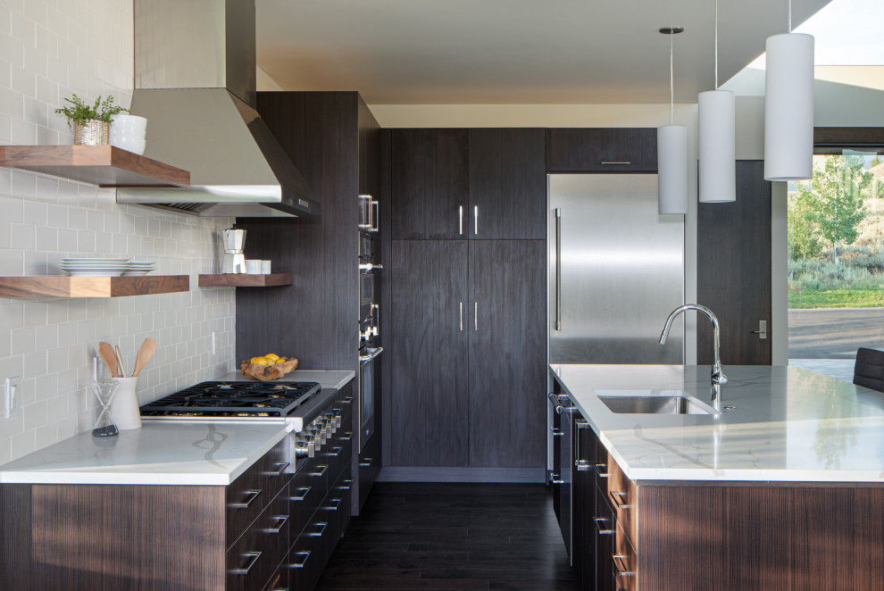 Inspiration for a contemporary l-shaped dark wood floor and brown floor kitchen remodel in Other with an undermount sink, flat-panel cabinets, dark wood cabinets, stainless steel appliances, an island and white countertops