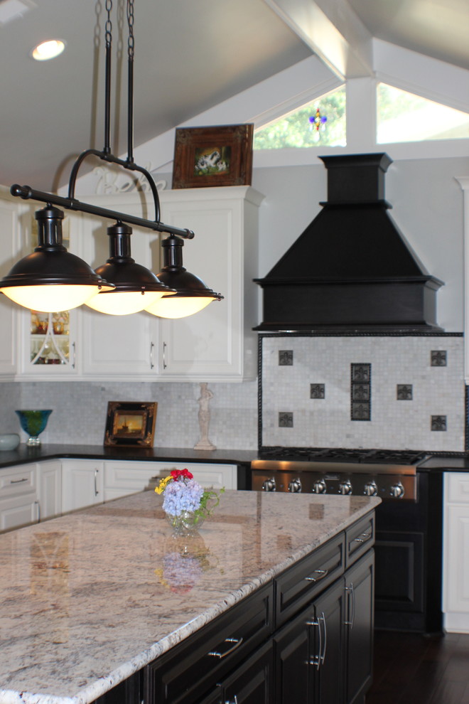 Foto på ett mellanstort vintage kök, med en undermonterad diskho, luckor med upphöjd panel, vita skåp, granitbänkskiva, beige stänkskydd, stänkskydd i porslinskakel, svarta vitvaror, laminatgolv och en köksö