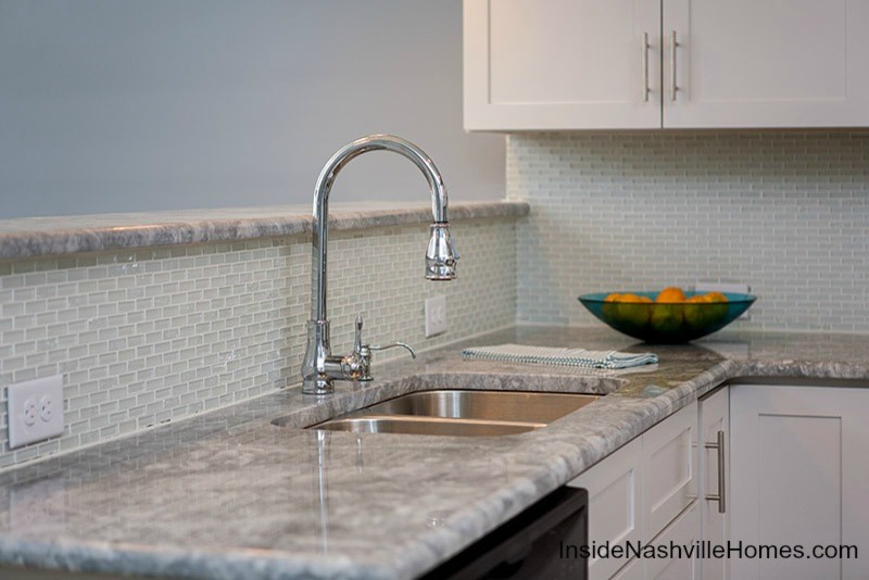 Classic u-shaped kitchen/diner in Nashville with a submerged sink, shaker cabinets, white cabinets, granite worktops, white splashback, glass tiled splashback and stainless steel appliances.