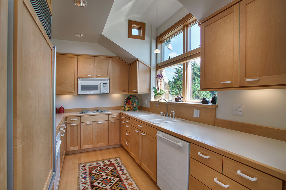 Geschlossene Klassische Küche ohne Insel in U-Form mit Einbauwaschbecken, Schrankfronten im Shaker-Stil, hellen Holzschränken, weißen Elektrogeräten und hellem Holzboden in Portland