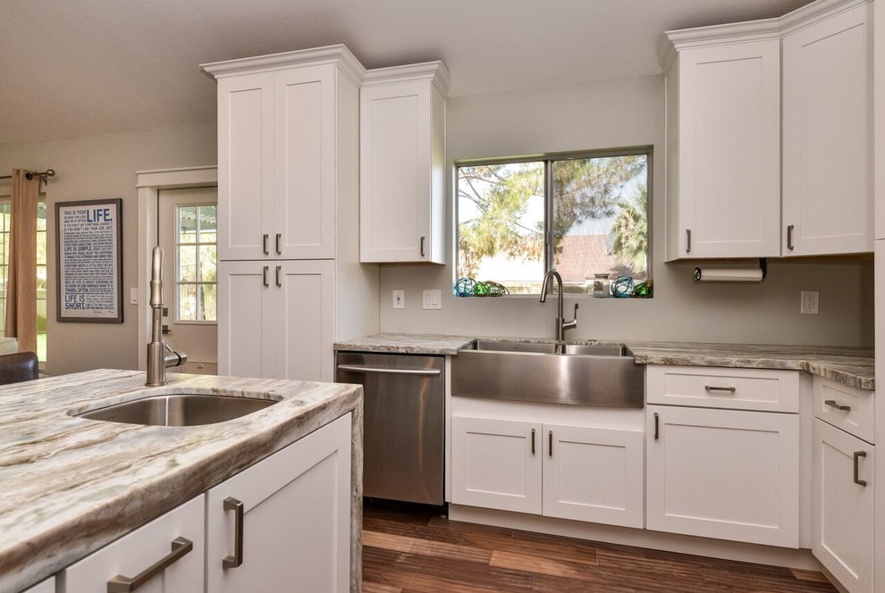 Photo of a medium sized beach style l-shaped open plan kitchen in Phoenix with a double-bowl sink, shaker cabinets, white cabinets, stainless steel appliances, medium hardwood flooring and an island.