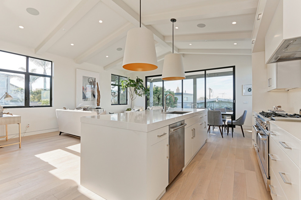 Mid-sized minimalist l-shaped light wood floor and beige floor open concept kitchen photo in Los Angeles with an undermount sink, flat-panel cabinets, white cabinets, quartzite countertops, white backsplash, stainless steel appliances and an island