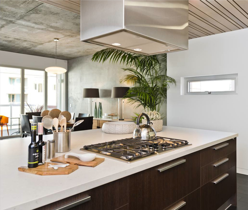 Inspiration for a mid-sized contemporary l-shaped open concept kitchen remodel in San Francisco with an integrated sink, flat-panel cabinets, dark wood cabinets, quartz countertops, stainless steel appliances and an island