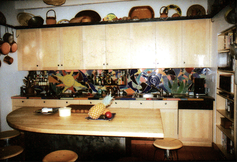 Mittelgroße Stilmix Küche in L-Form mit Vorratsschrank, Schrankfronten im Shaker-Stil, hellen Holzschränken, Arbeitsplatte aus Fliesen, bunter Rückwand, Rückwand aus Keramikfliesen, schwarzen Elektrogeräten und Terrakottaboden in Phoenix