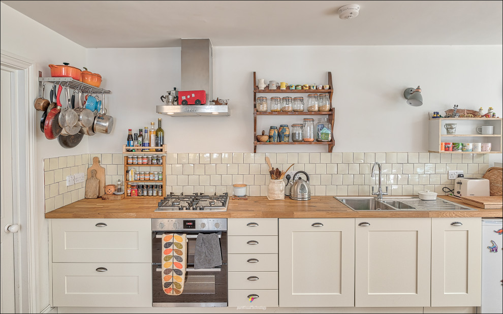 Example of a mid-sized eclectic single-wall eat-in kitchen design in London with no island