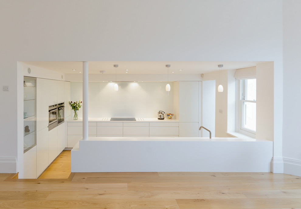 Пример оригинального дизайна: кухня в современном стиле с плоскими фасадами и белыми фасадами