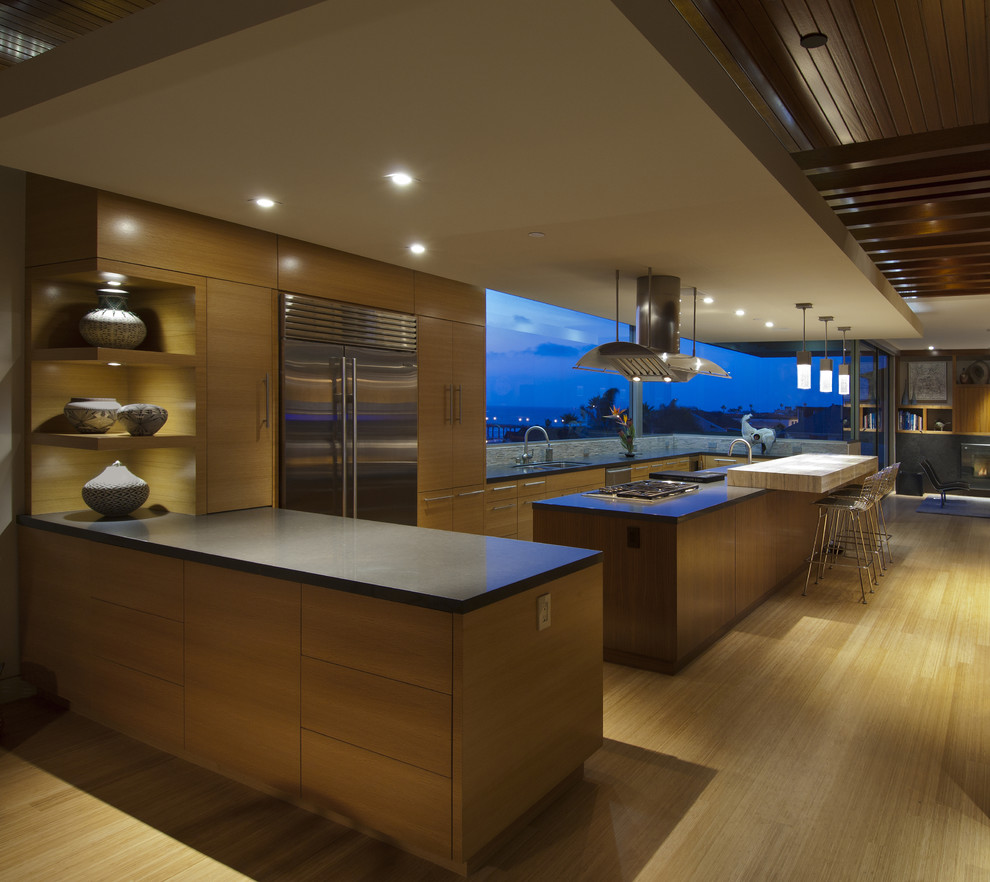 Example of a trendy galley open concept kitchen design in Los Angeles with flat-panel cabinets, light wood cabinets and stainless steel appliances