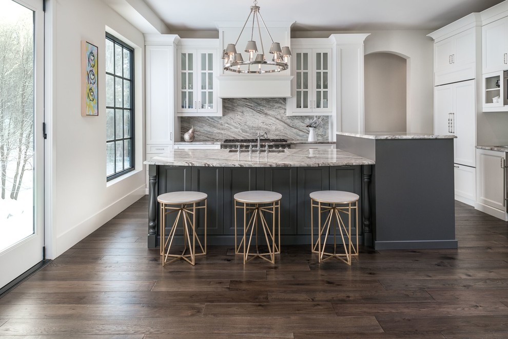 Inspiration for a large transitional l-shaped dark wood floor open concept kitchen remodel with an island, an undermount sink, recessed-panel cabinets, white cabinets, marble countertops, white backsplash, stone slab backsplash and stainless steel appliances