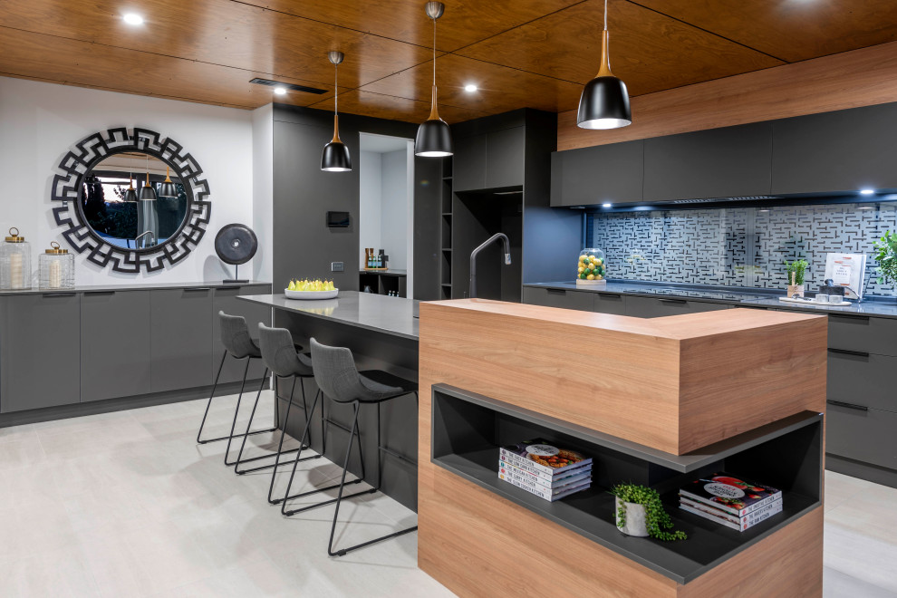 Inspiration for a large contemporary galley light wood floor and white floor open concept kitchen remodel in Canberra - Queanbeyan with flat-panel cabinets, black cabinets, glass sheet backsplash, black appliances, an island and gray countertops