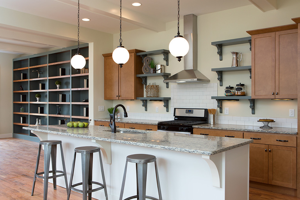 Inspiration for a mid-sized industrial single-wall medium tone wood floor eat-in kitchen remodel in Nashville with an undermount sink, shaker cabinets, medium tone wood cabinets, granite countertops, white backsplash, subway tile backsplash, stainless steel appliances and an island
