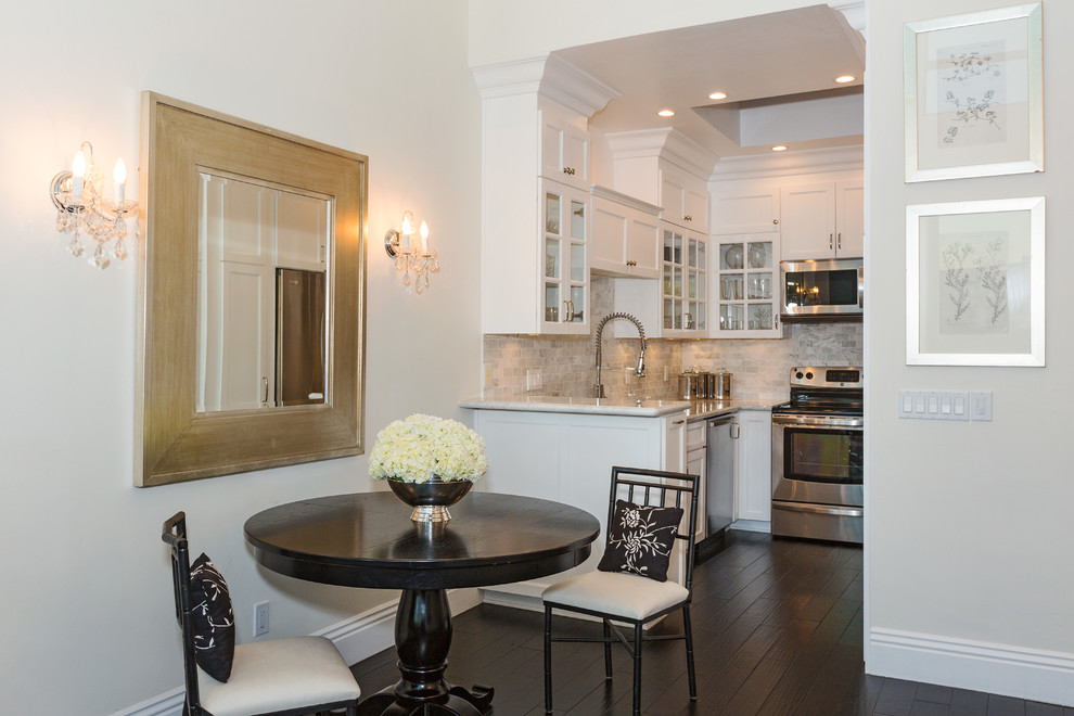 Photo of a traditional kitchen/diner in Los Angeles with white cabinets, marble worktops, white splashback, stainless steel appliances and shaker cabinets.