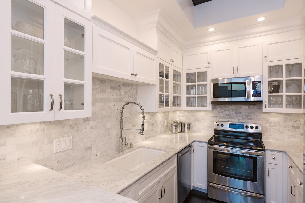 Transitional galley kitchen photo in Los Angeles with white cabinets, marble countertops, multicolored backsplash and stainless steel appliances